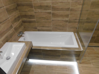 Nová koupelna v bytě s vanou a sprchovým koutem